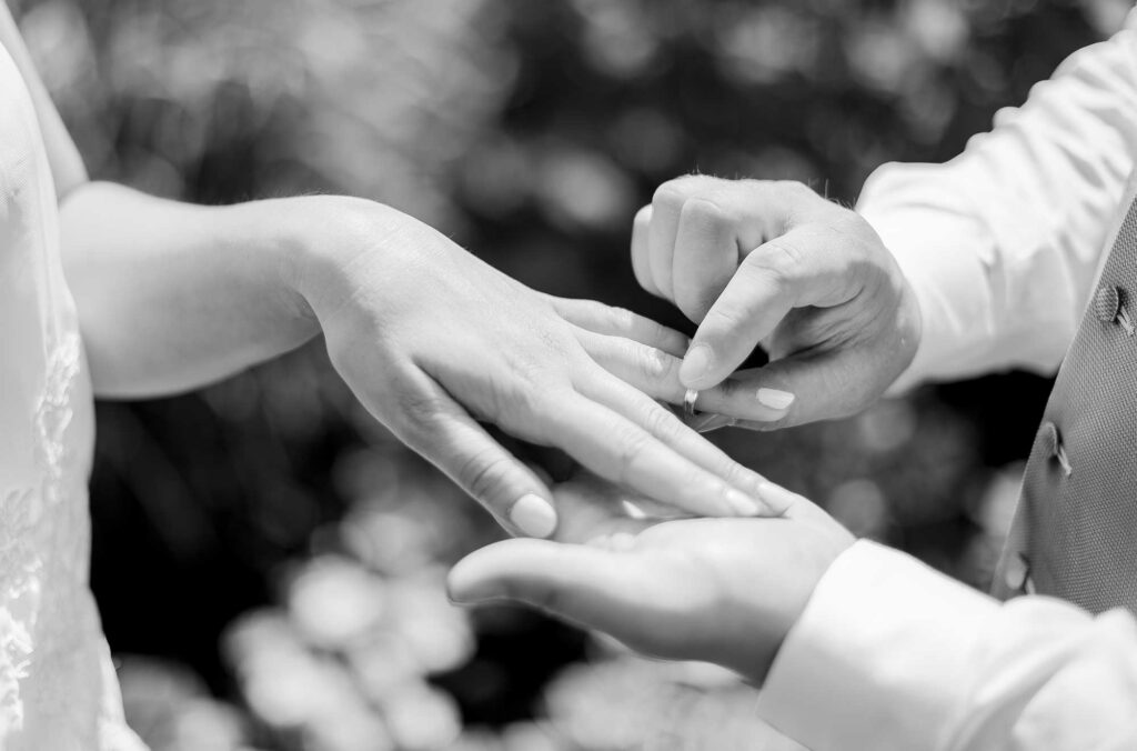 Mariée passant une alliance au doigt de son marié pendant la cérémonie