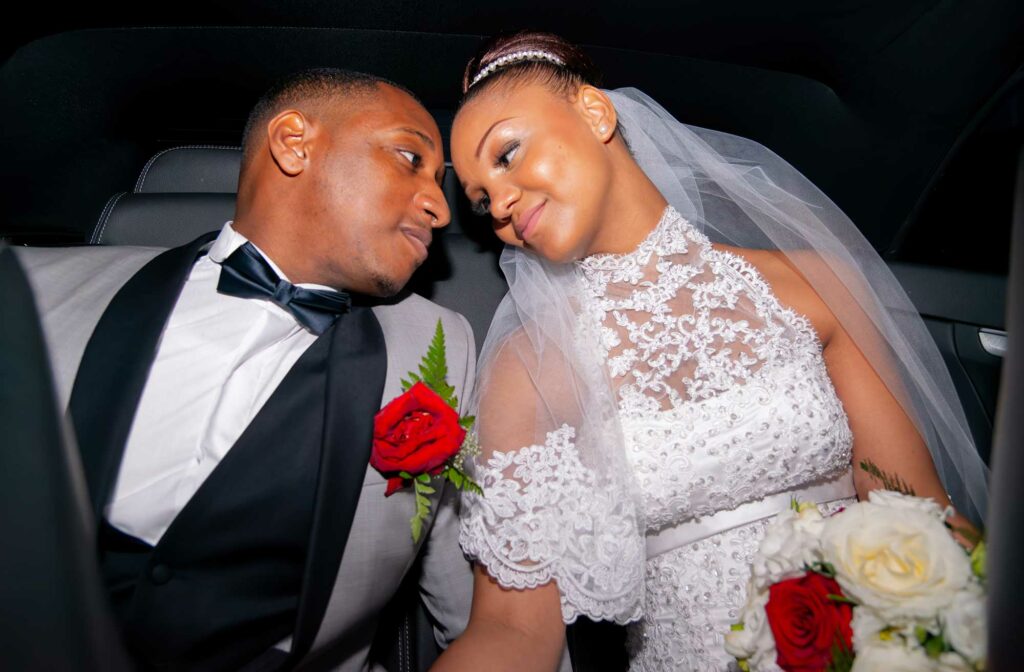 Couple de mariés enlacé à l'intérieur d'une voiture